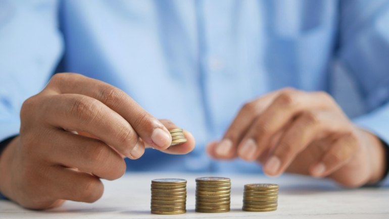 a person stacking coins on top of a table